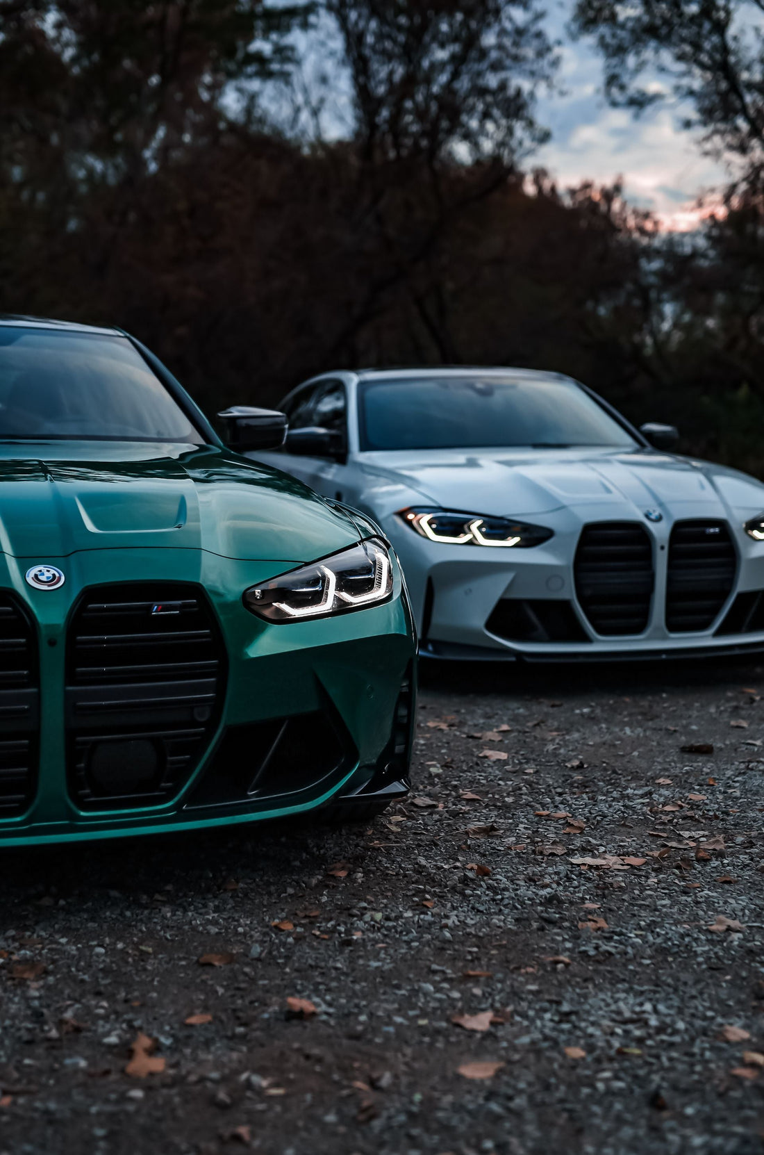 Two BMW M3 performance cars parked outdoors at dusk